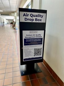 picture of our air quality drop box, which is black with white stickers on it. 